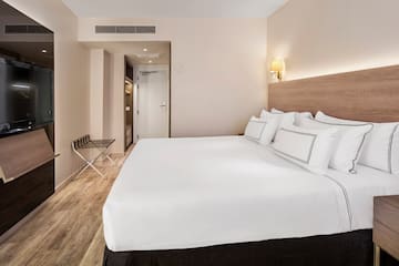 a bed with white sheets and a wood floor