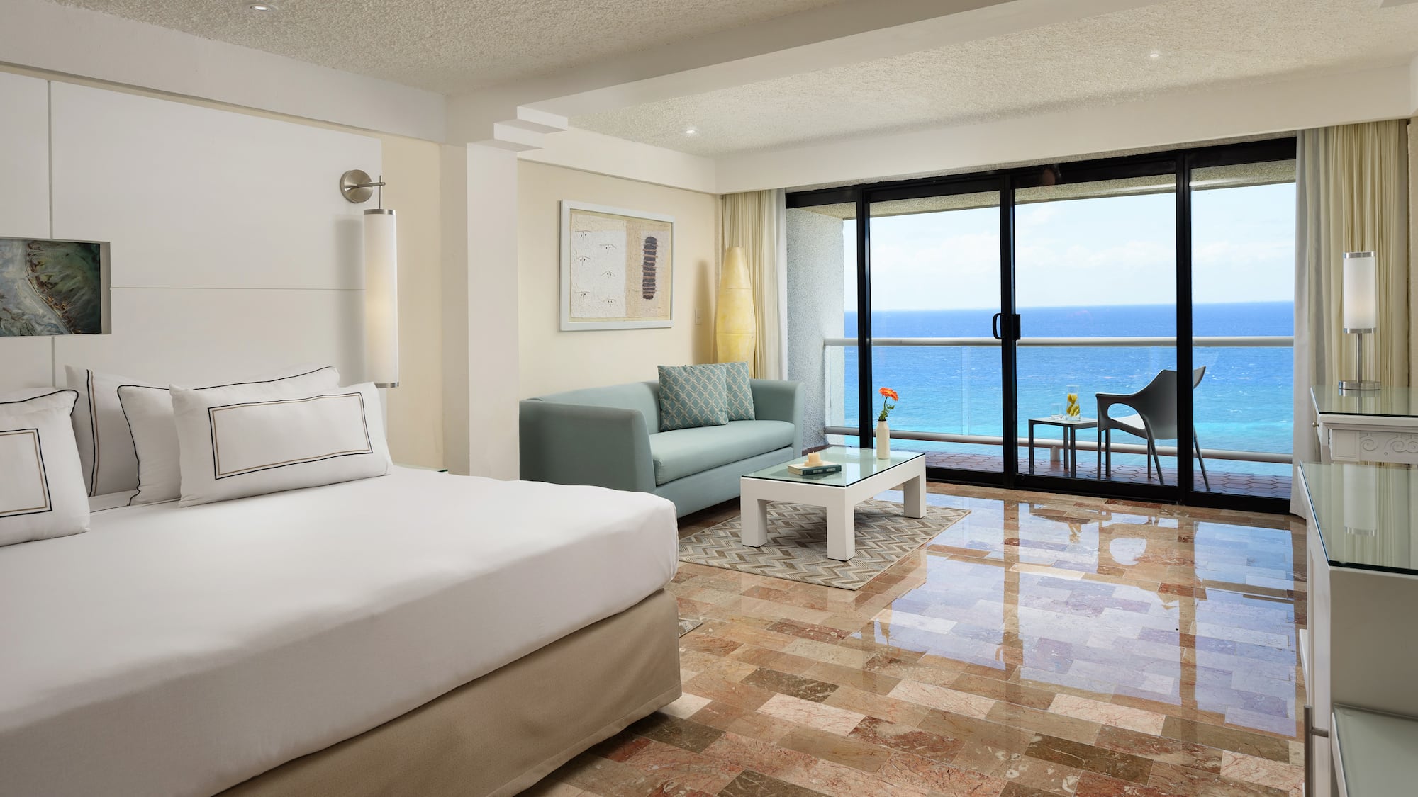 a room with a bed and a couch and a glass door