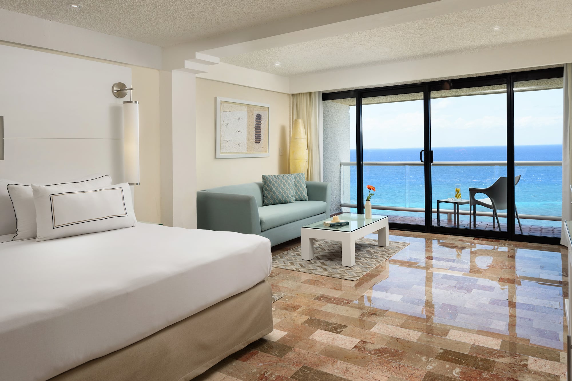 a room with a bed and a couch and a glass door