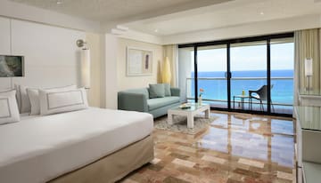 a room with a bed and a couch and a glass door