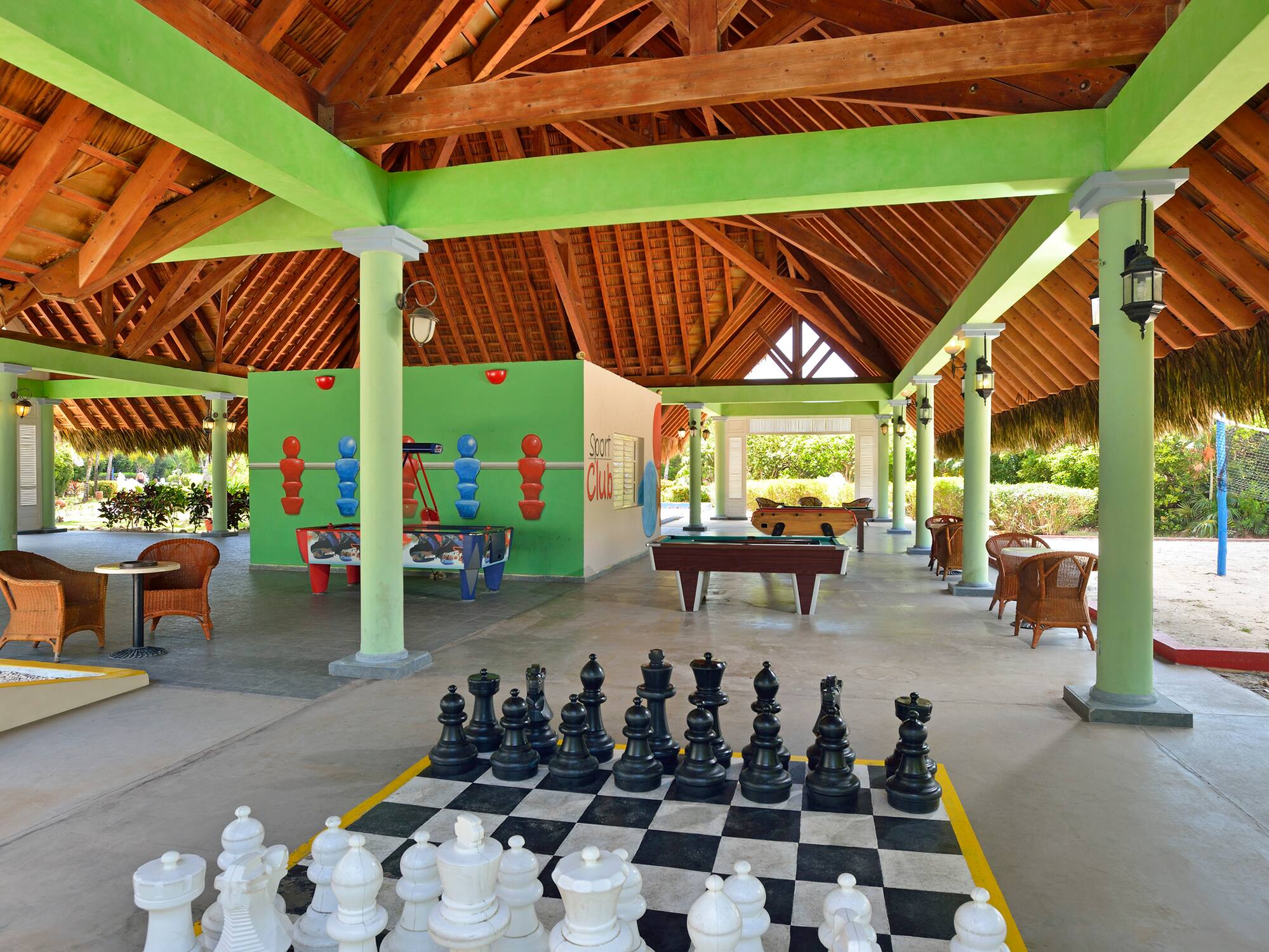 a large chess board in a room with tables and pool tables