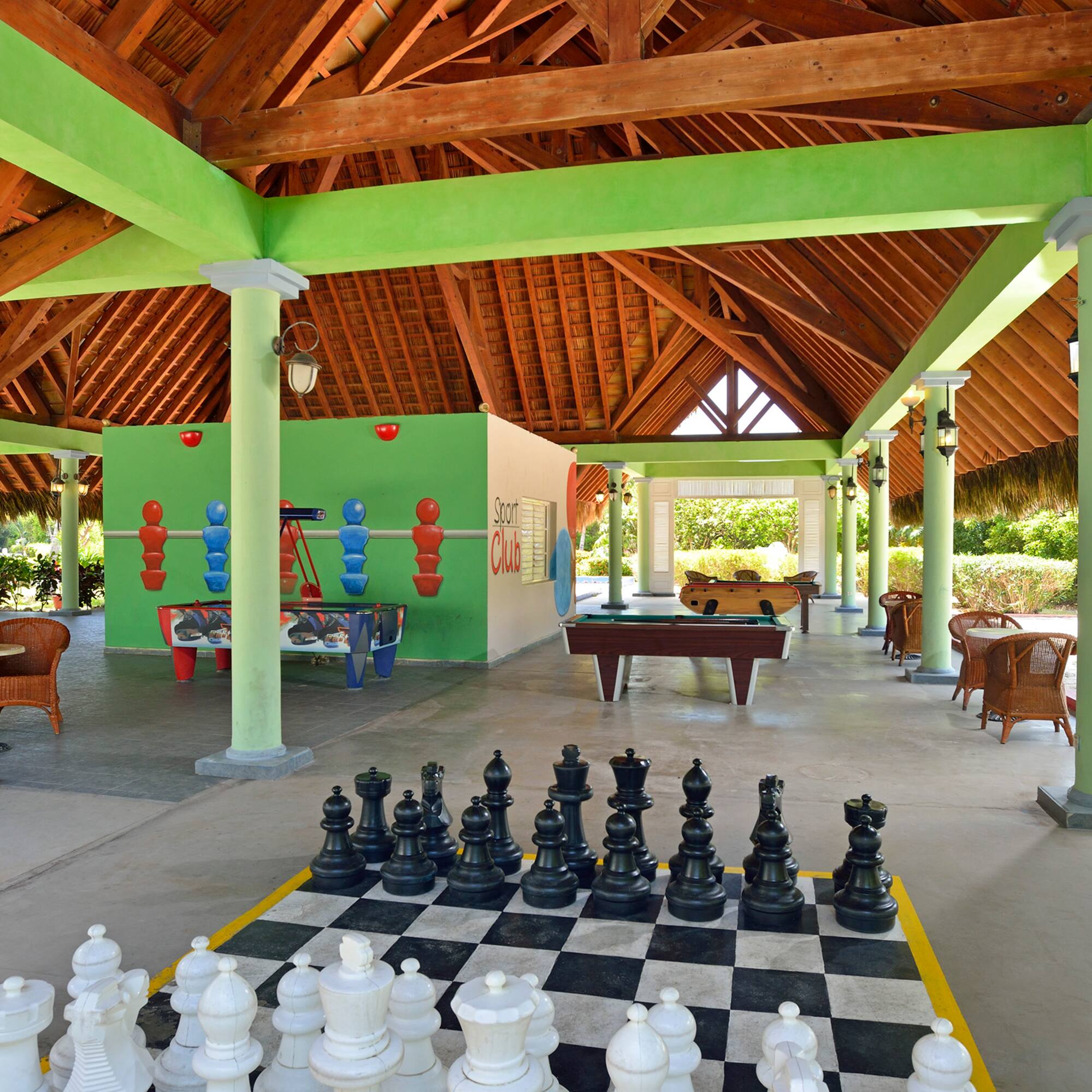 a large chess board in a room with tables and pool tables