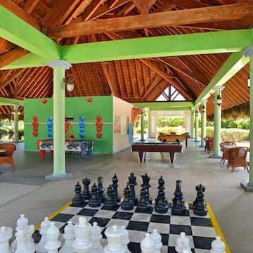 a large chess board in a room with tables and pool tables