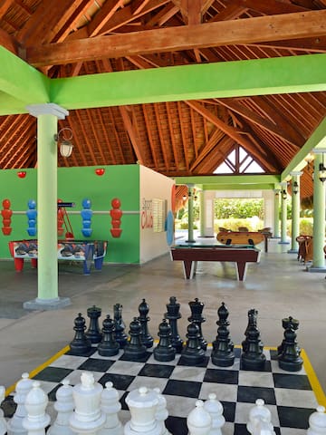a large chess board in a room with tables and pool tables