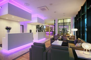 a lobby with purple lights and a reception desk