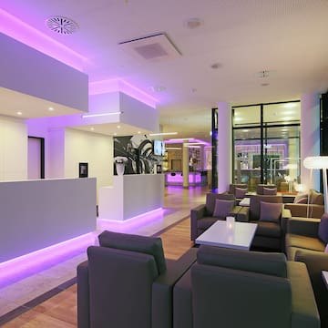 a lobby with purple lights and a reception desk