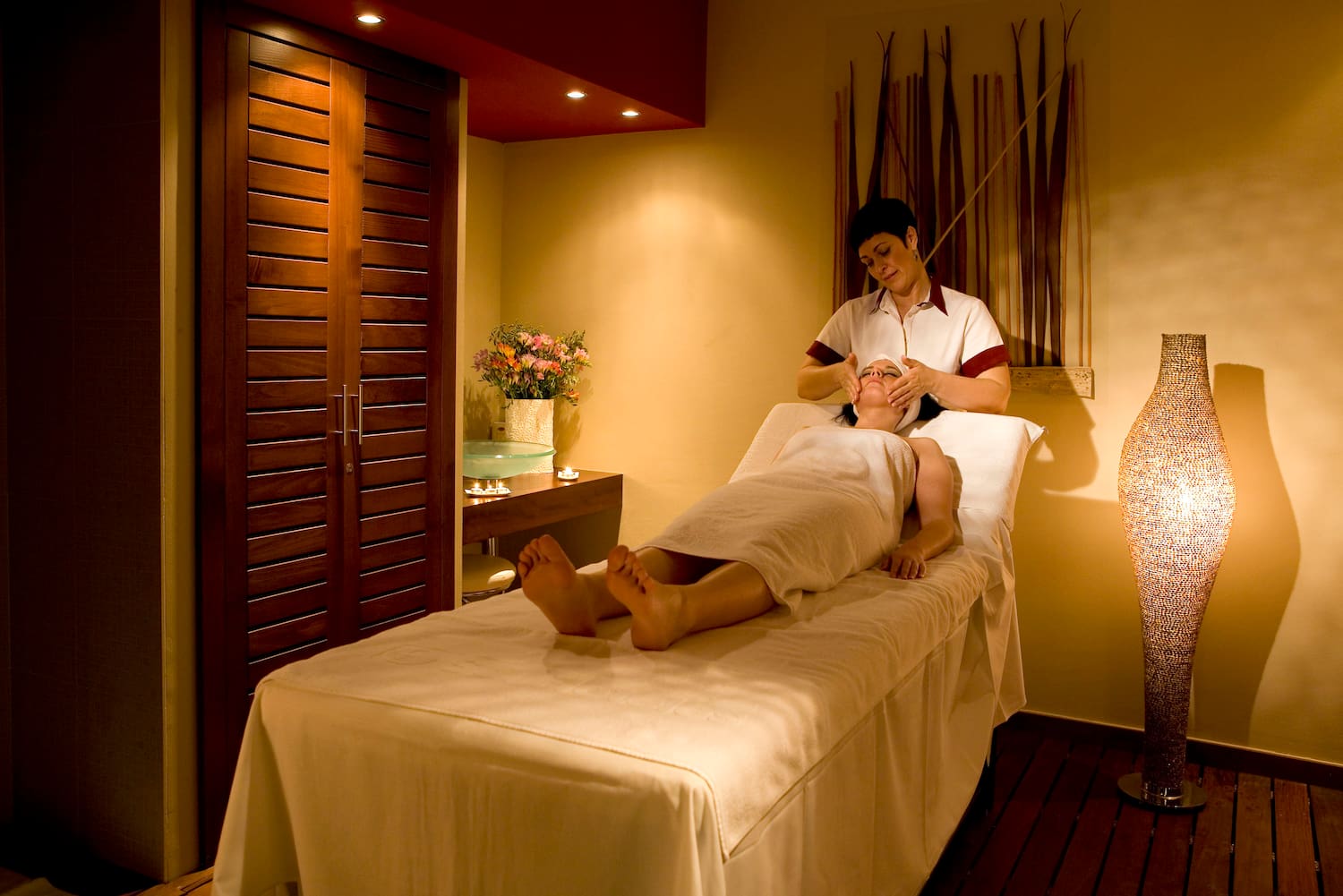 a woman lying on a bed with a massage stick