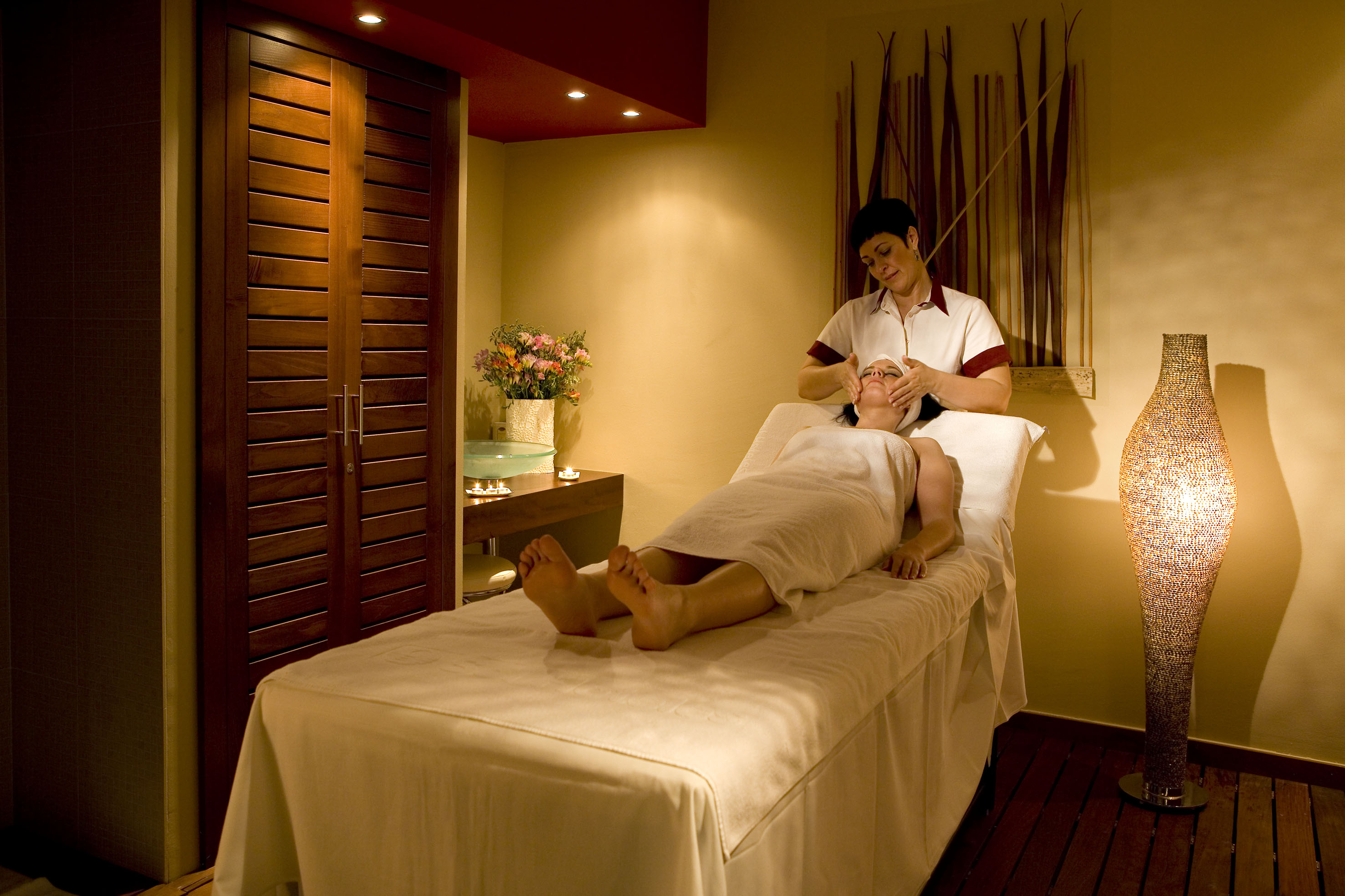 a woman lying on a bed with a massage stick