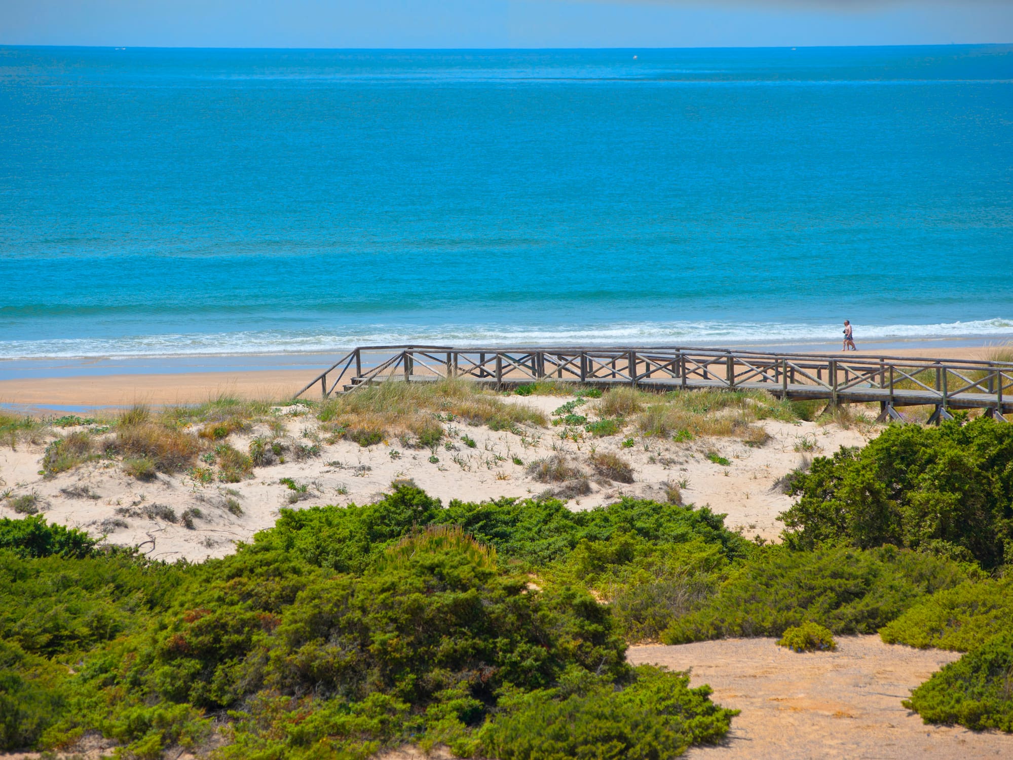a wooden bridge over a beach