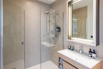 a bathroom with a glass shower and sink