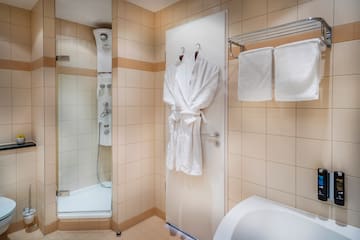 a bathroom with white bathrobes and towels