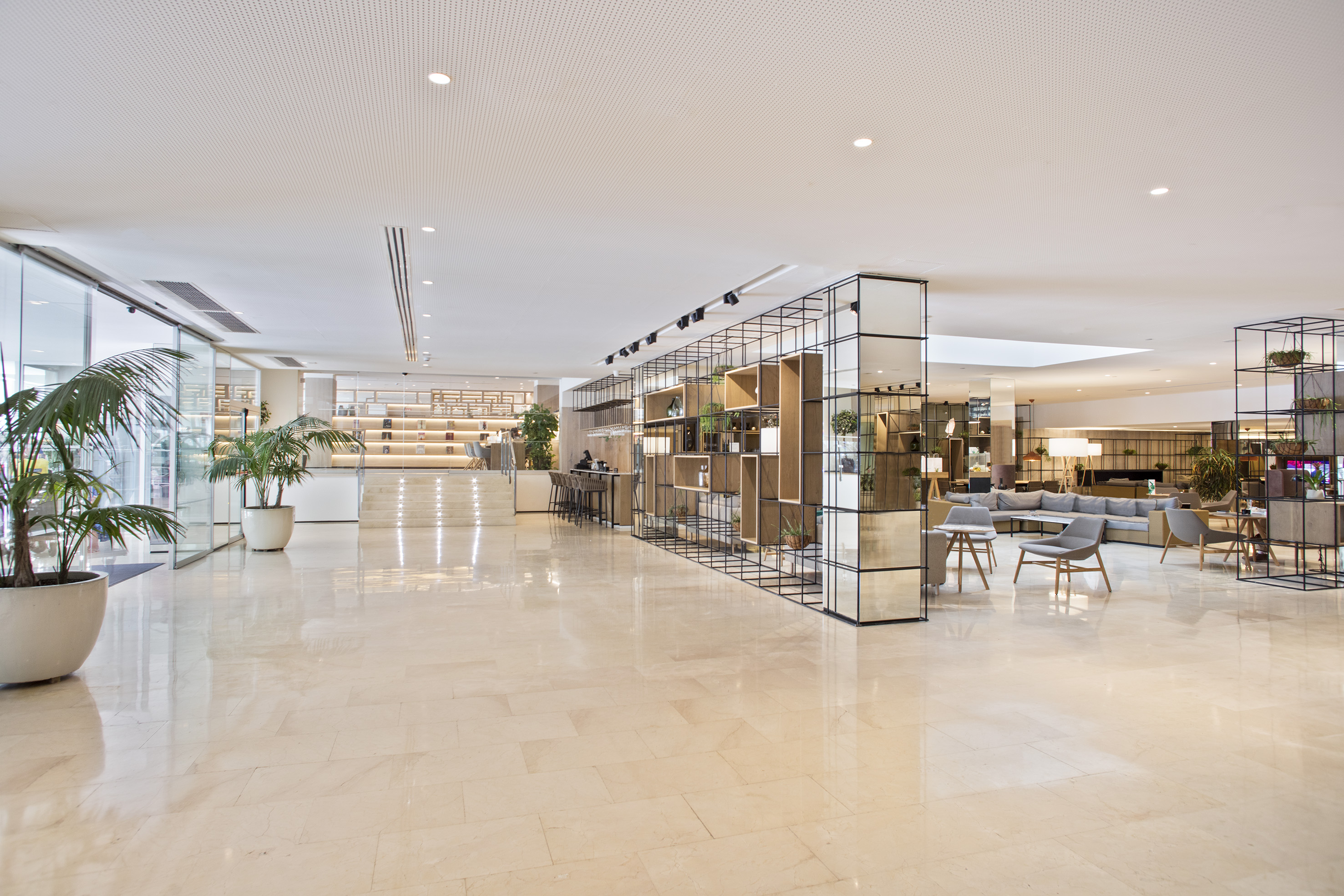 Luxury hotel lobby, modern design with lounge seating, marble floor, and bar.