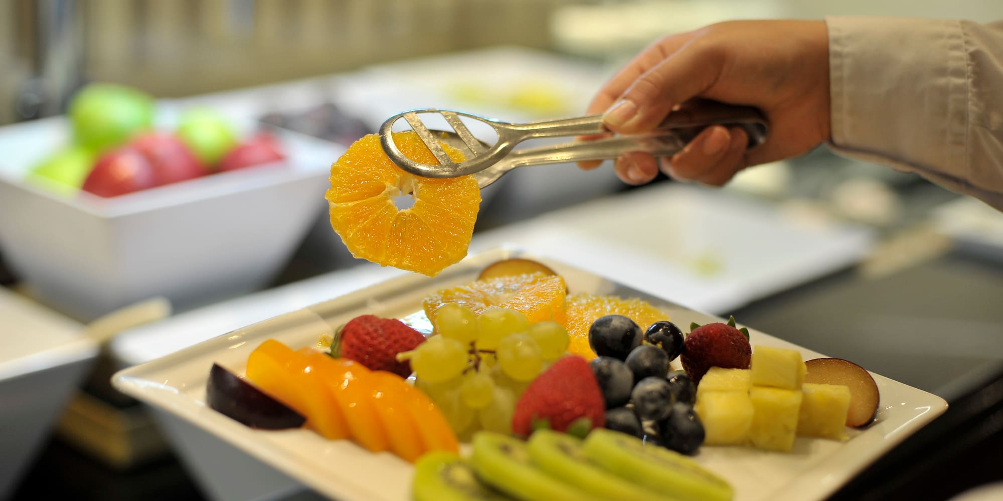 a person holding a plate of fruit