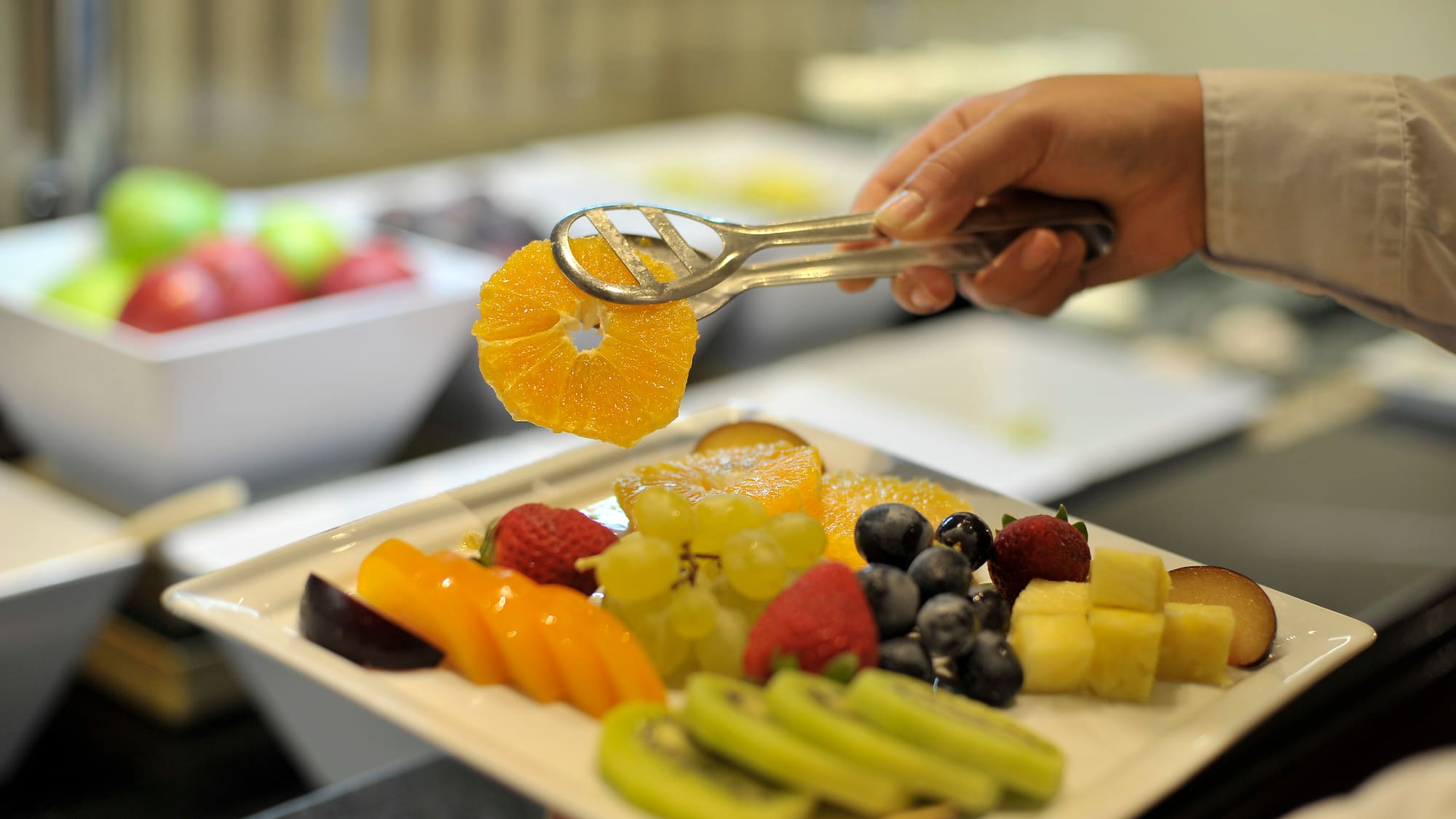 a person holding a plate of fruit