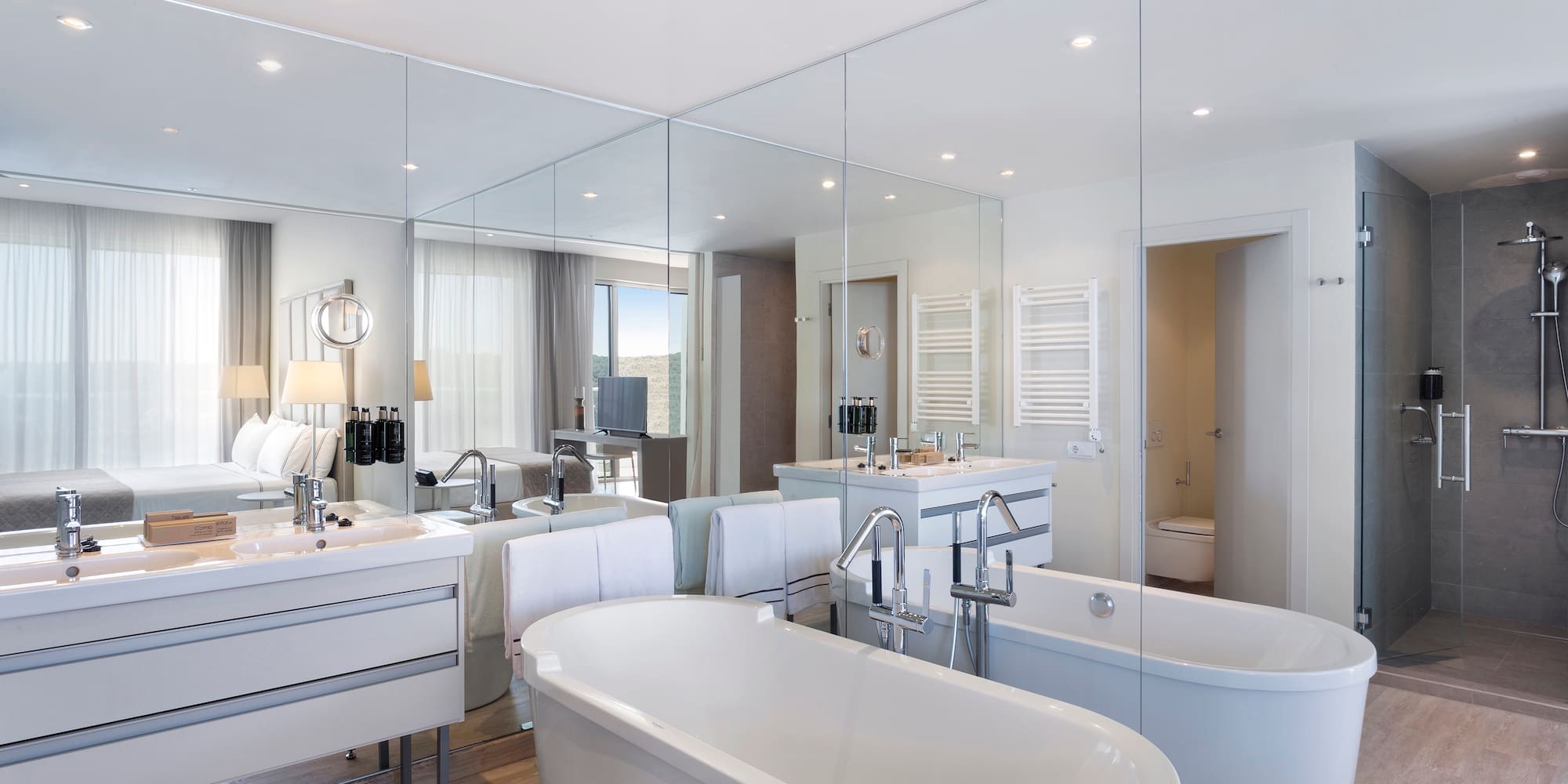 a bathroom with large mirrors and tubs