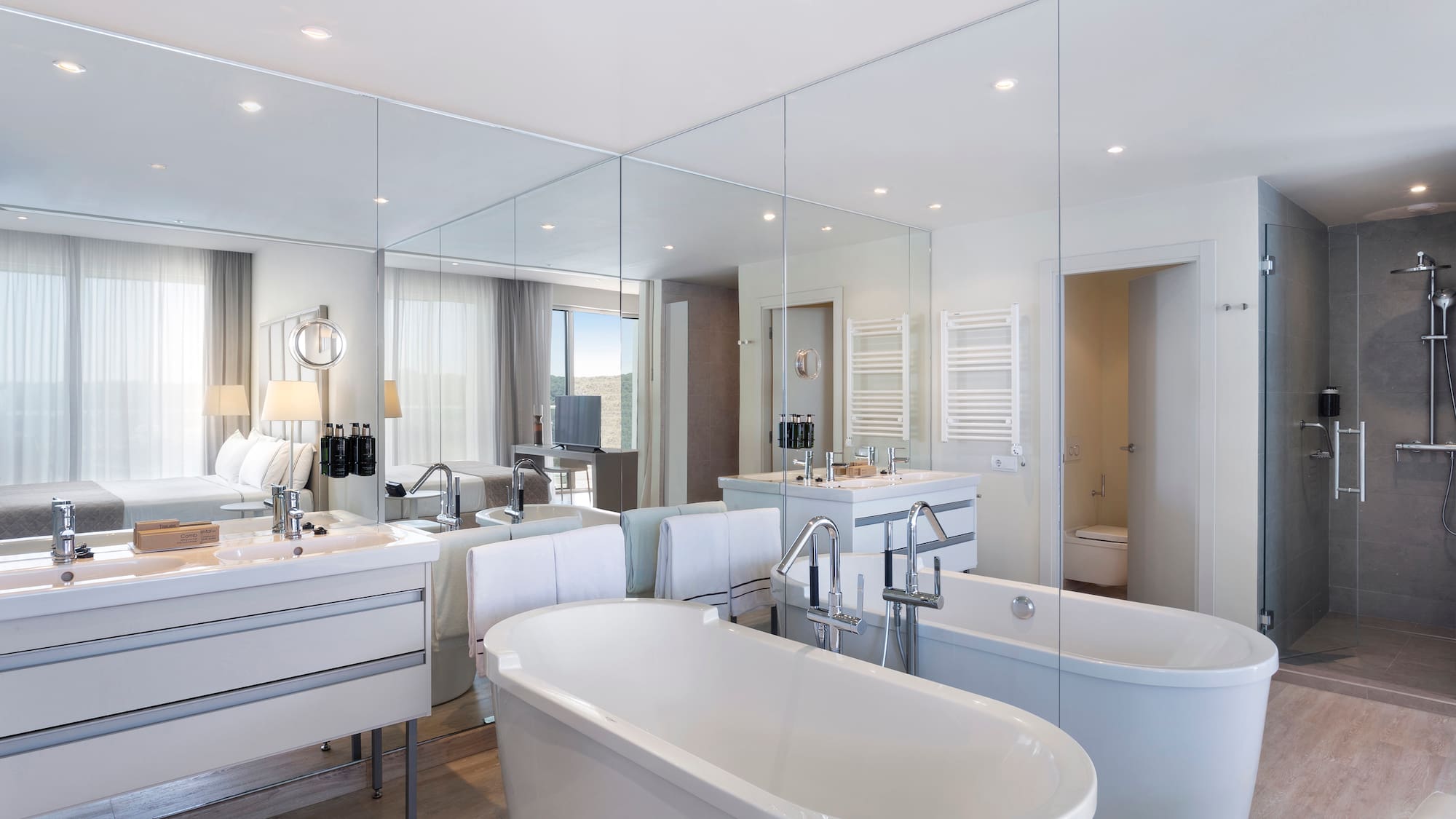 a bathroom with large mirrors and tubs