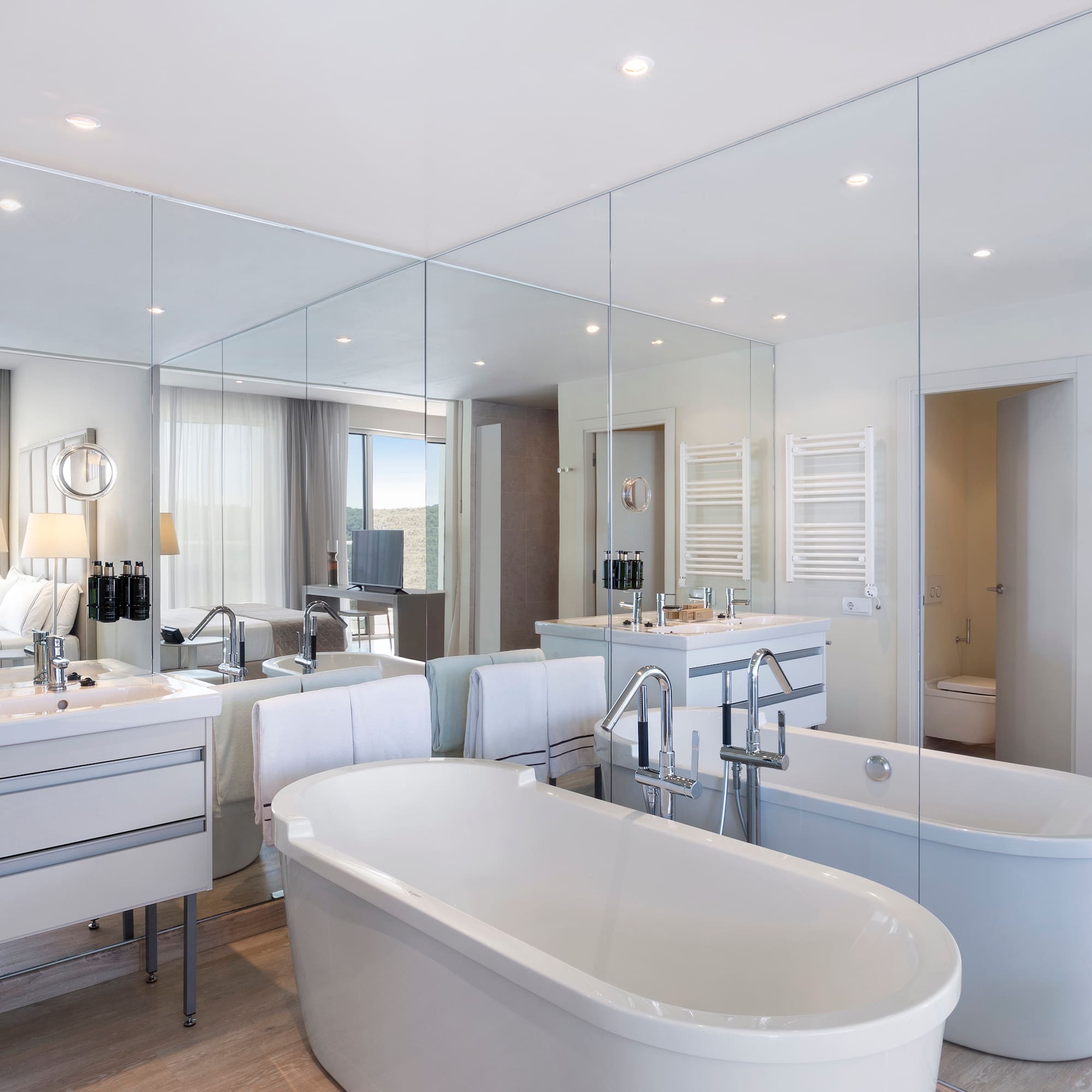 a bathroom with large mirrors and tubs