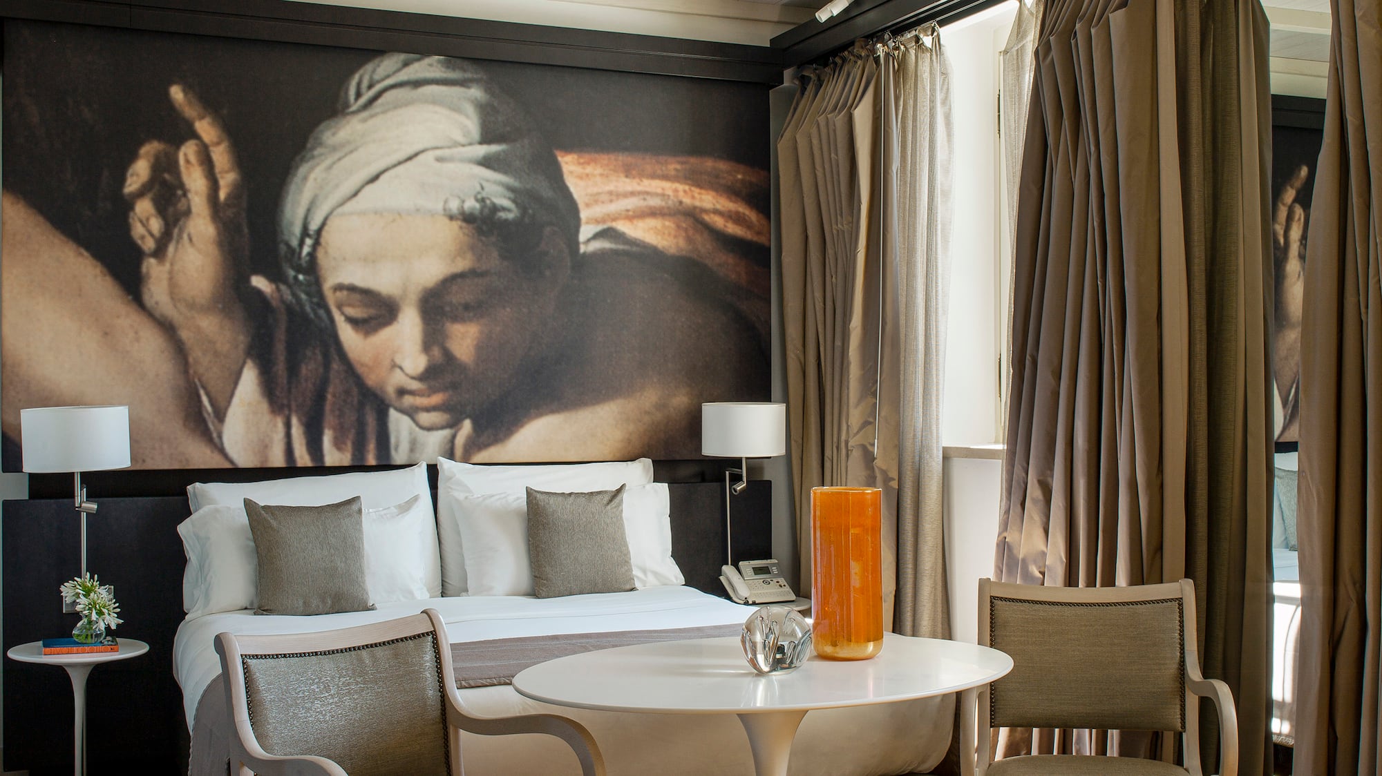 a room with a bed and chairs