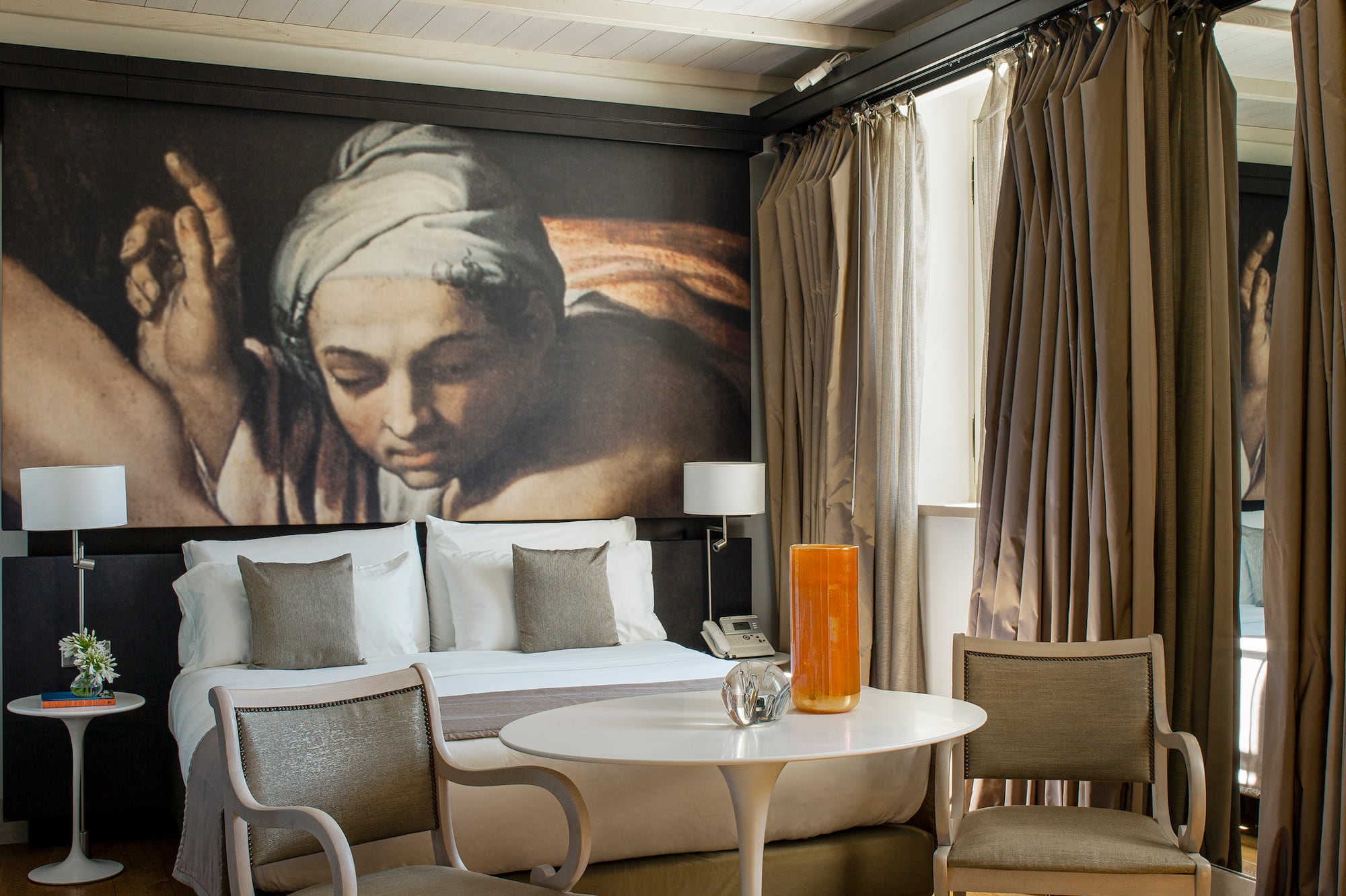 a room with a bed and chairs