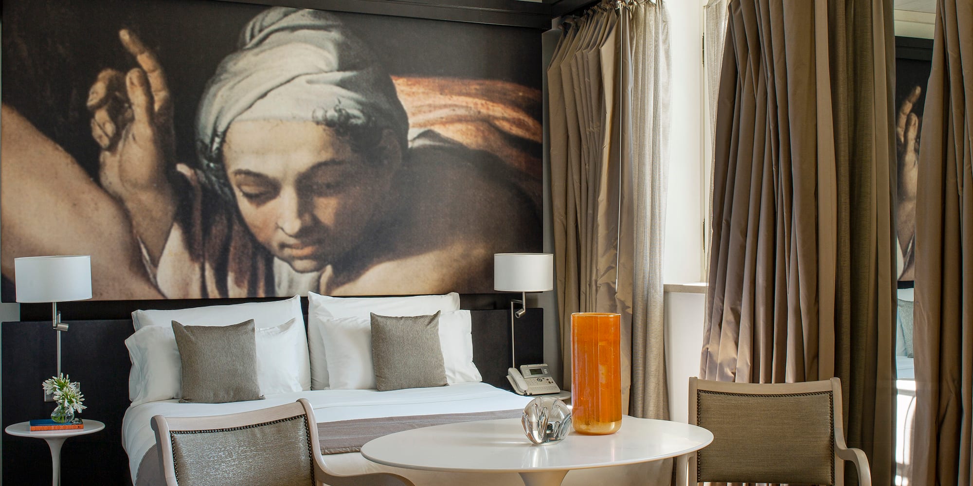 a room with a bed and chairs