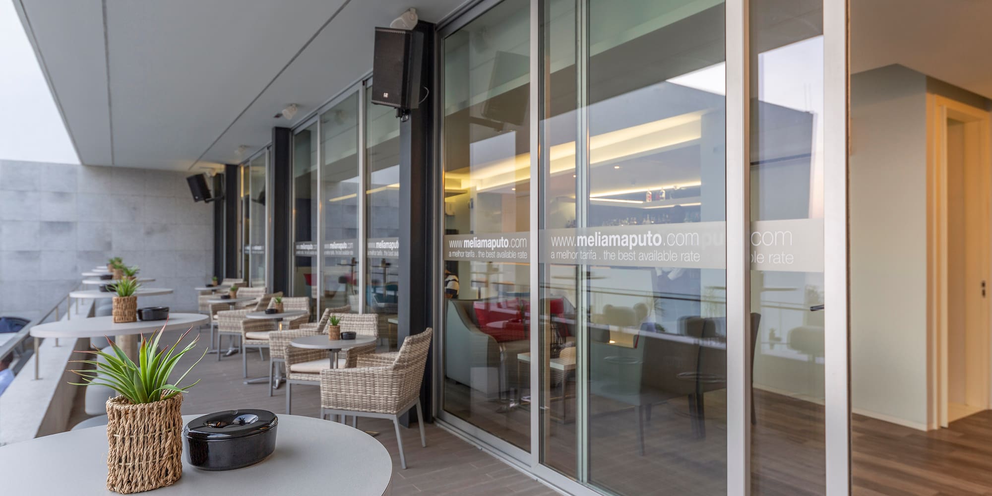 a glass wall with a table and chairs outside