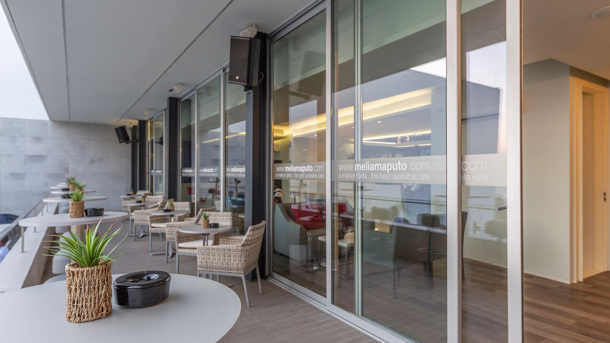 a glass wall with a table and chairs outside