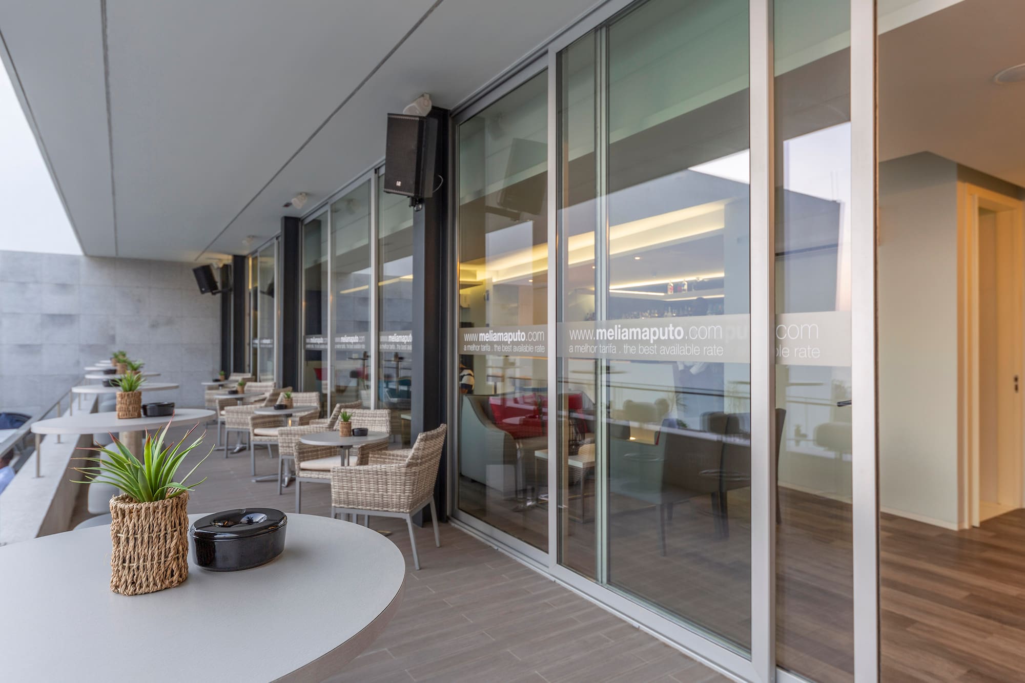 a glass wall with a table and chairs outside