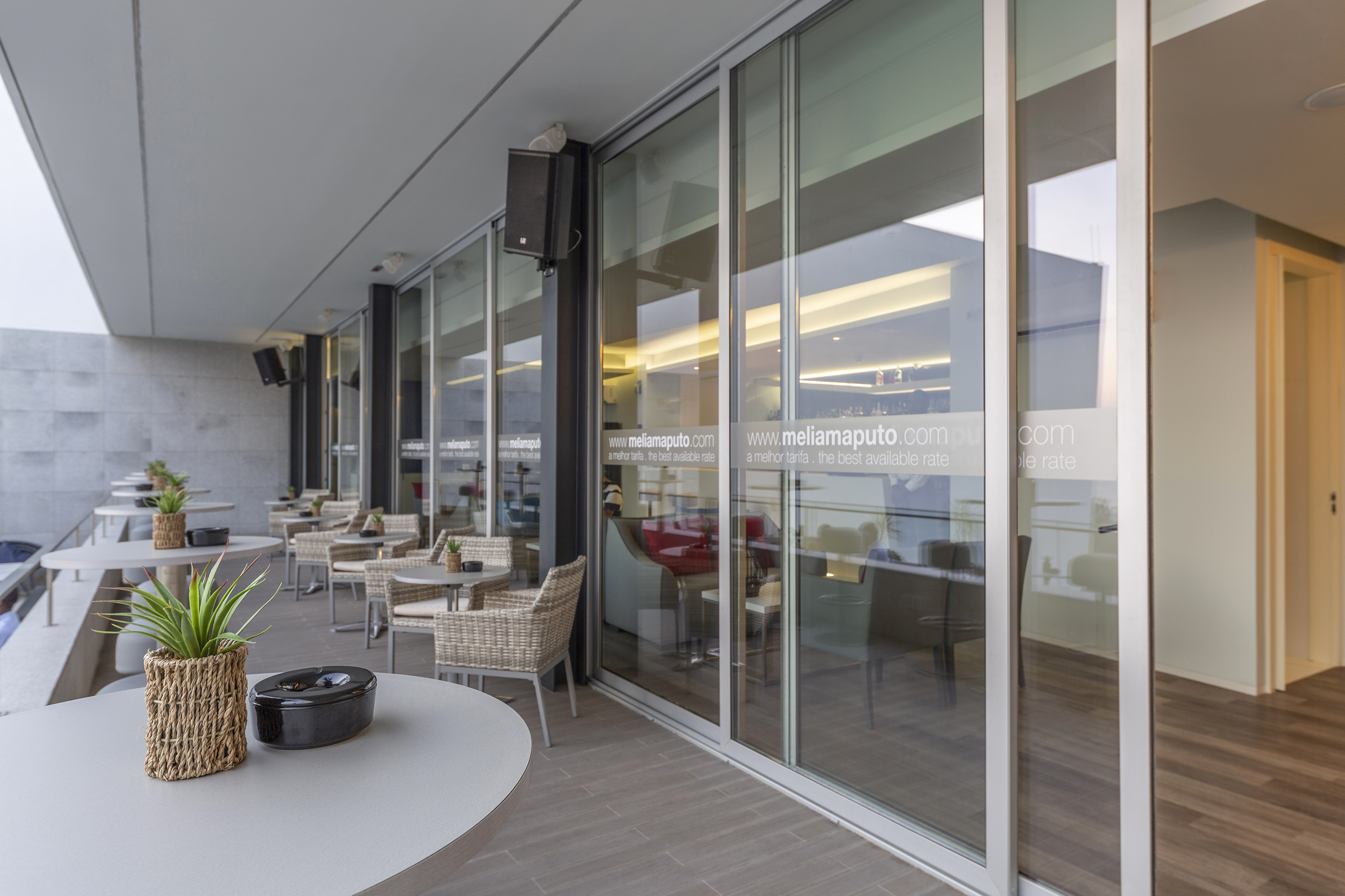 a glass wall with a table and chairs outside