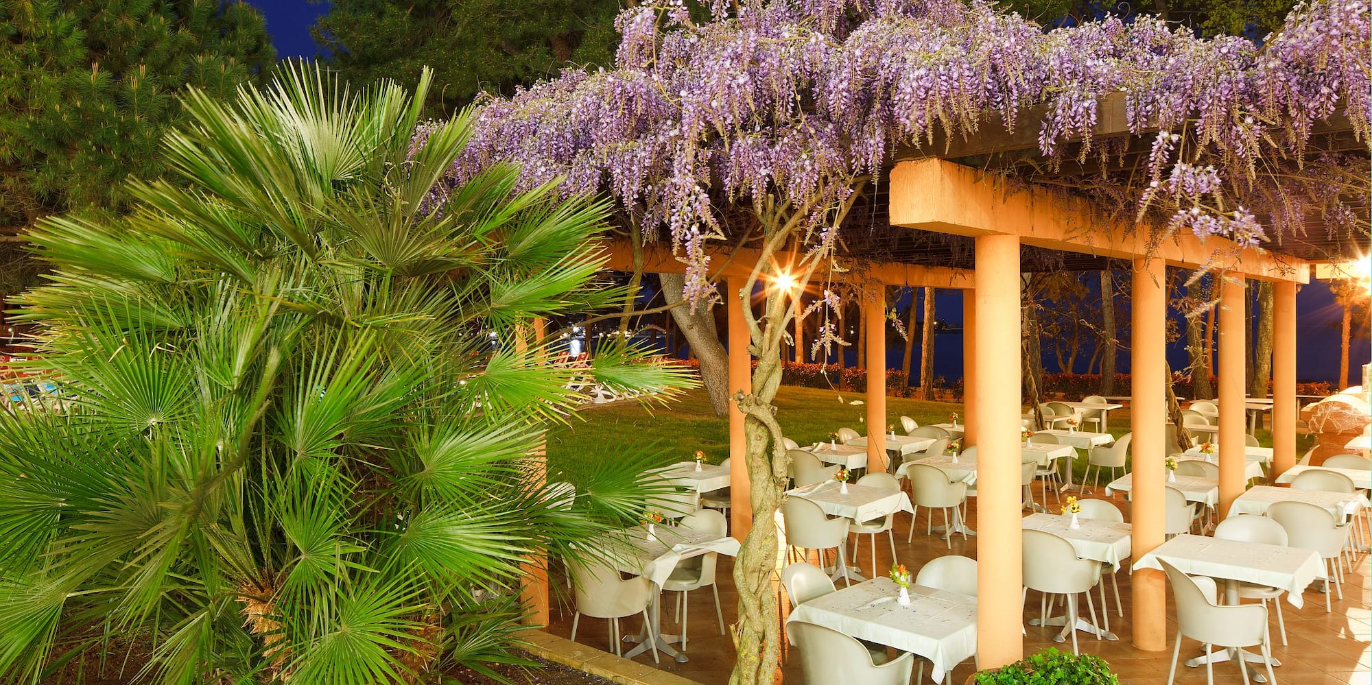 a covered patio with tables and chairs