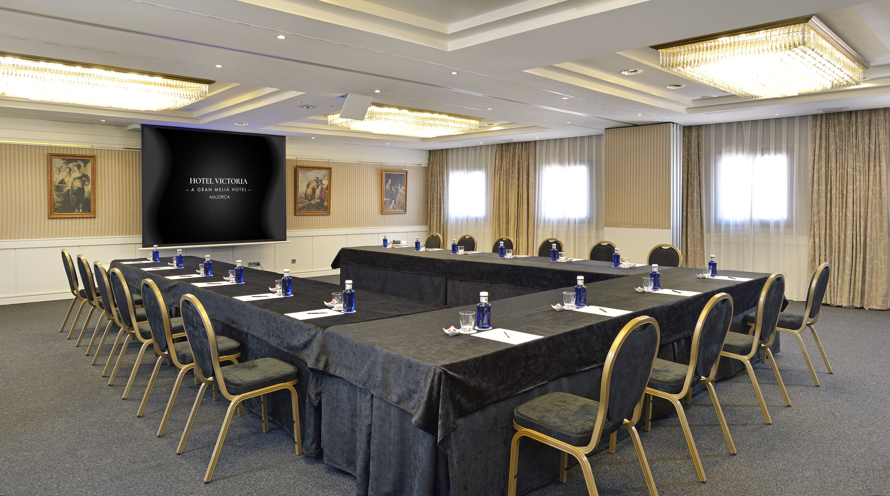 Business meeting room at Hotel Victoria Mallorca with U-shape table and screen.