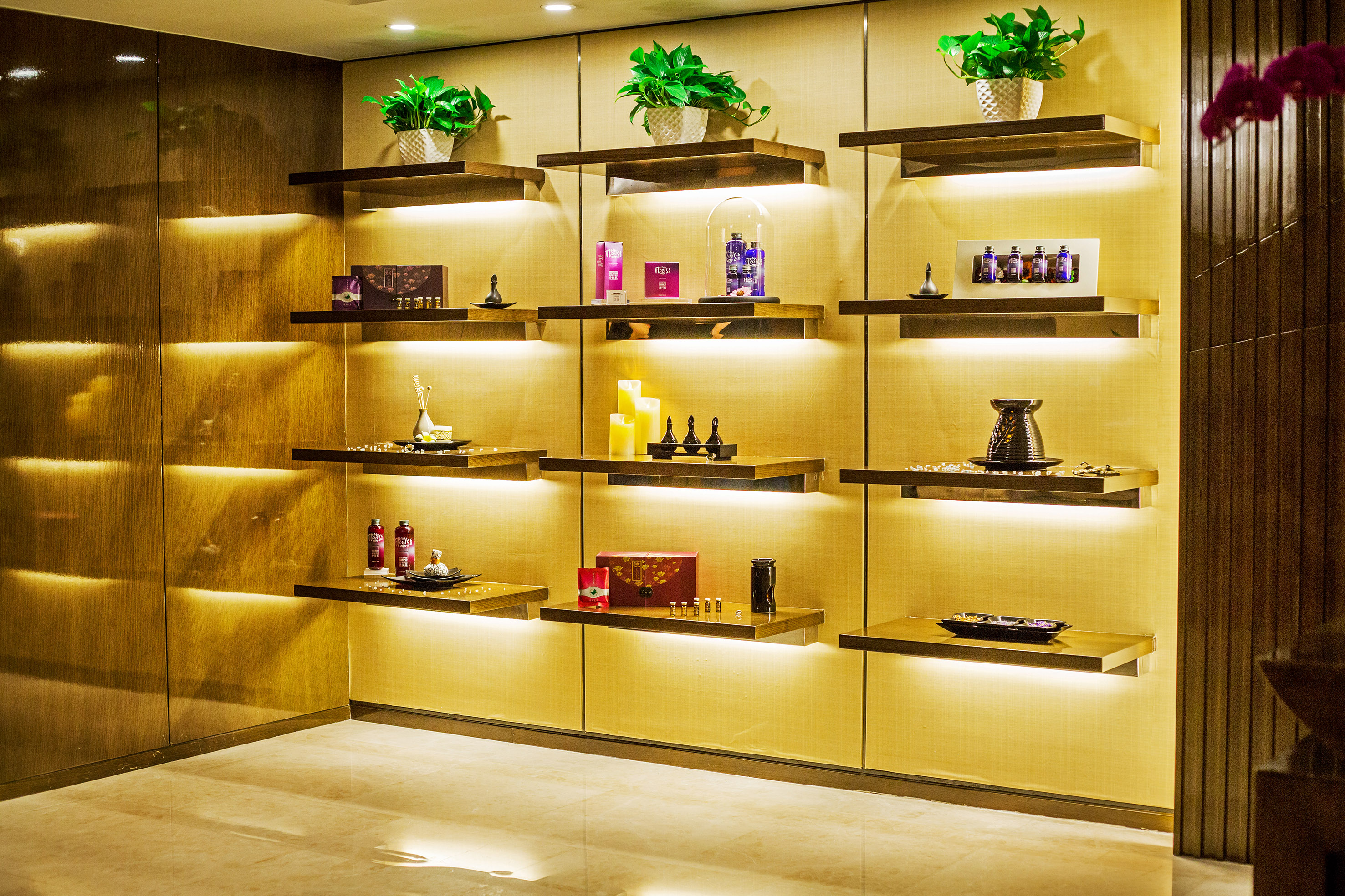 Backlit shelves with luxury spa products, essential oils, and wellness decor.