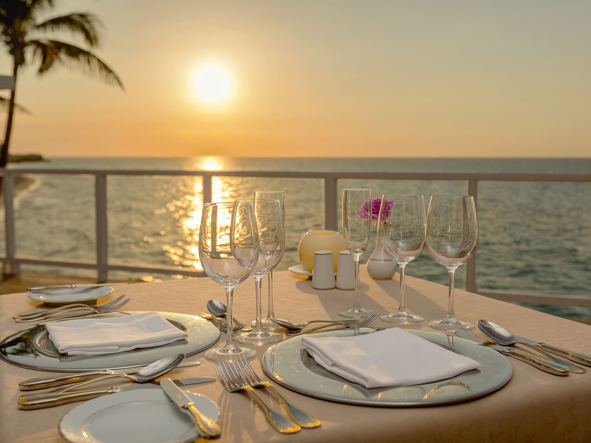 a table set for a dinner with a view of the ocean