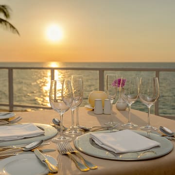 a table set for a dinner with a view of the ocean