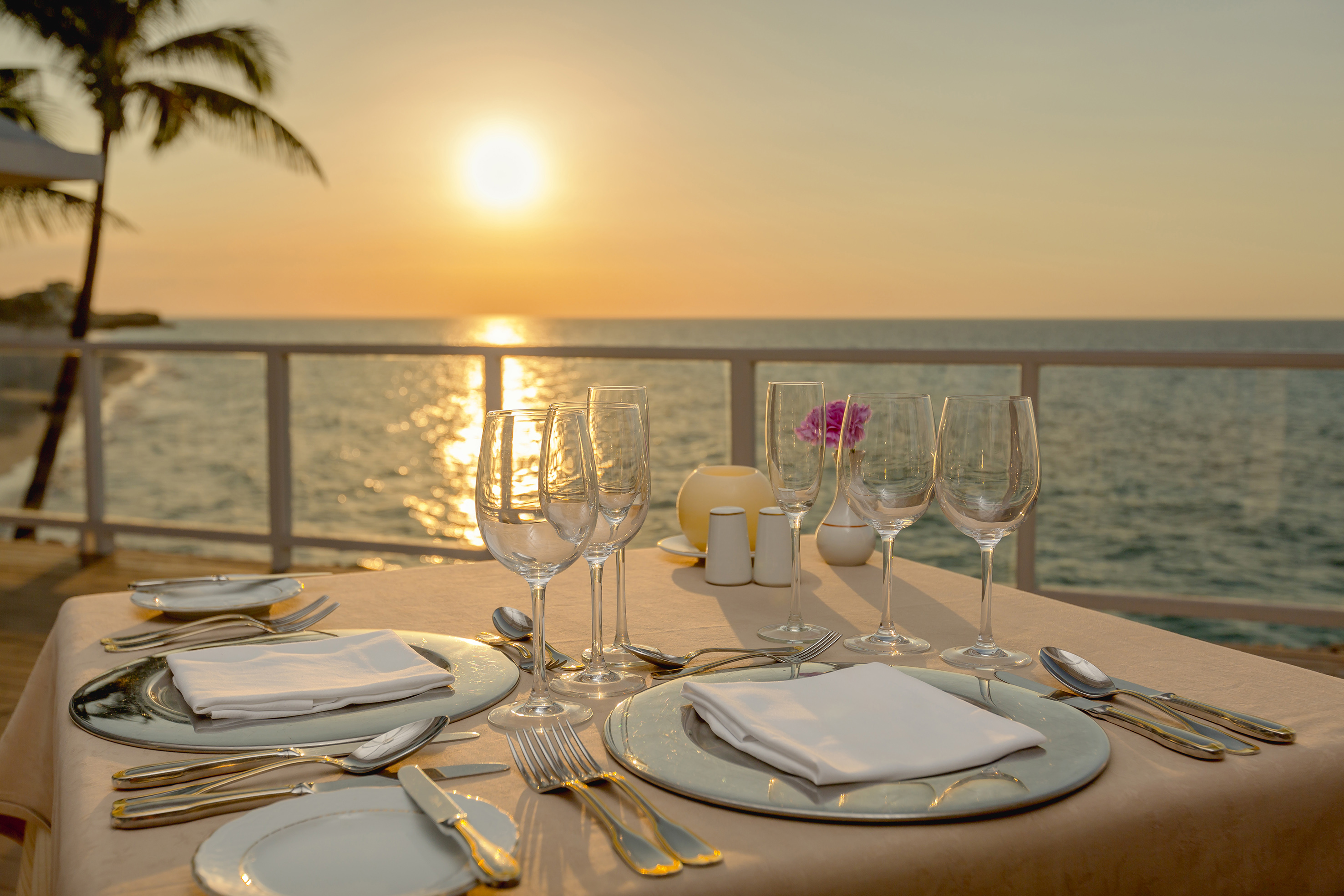 a table set for a dinner with a view of the ocean