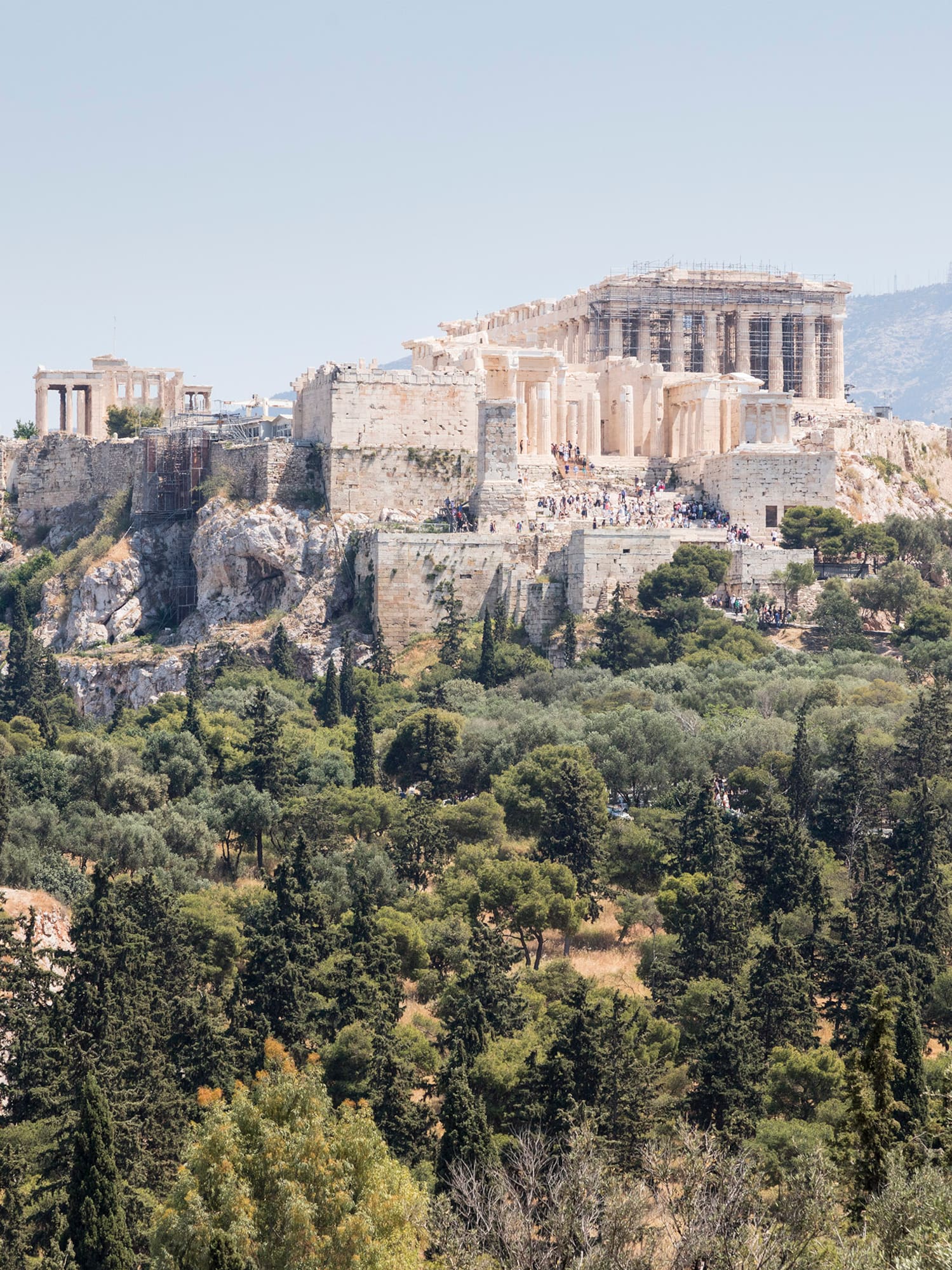 a stone building on a hill with trees