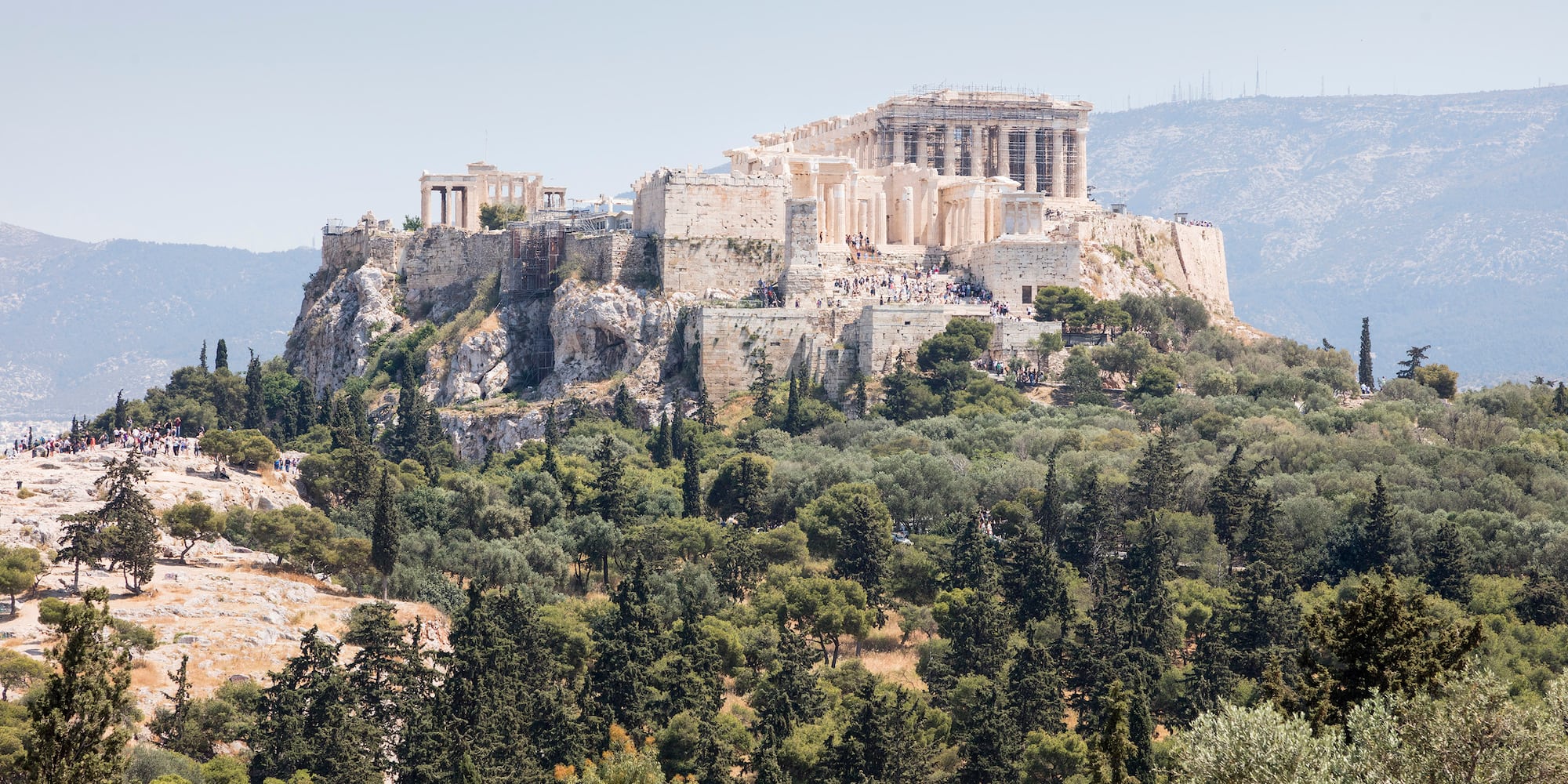a stone building on a hill with trees