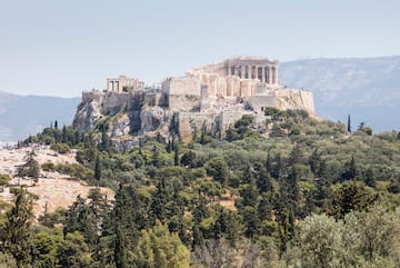 a stone building on a hill with trees