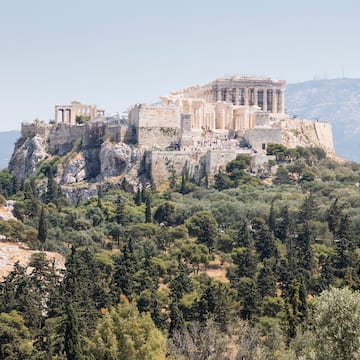 a stone building on a hill with trees