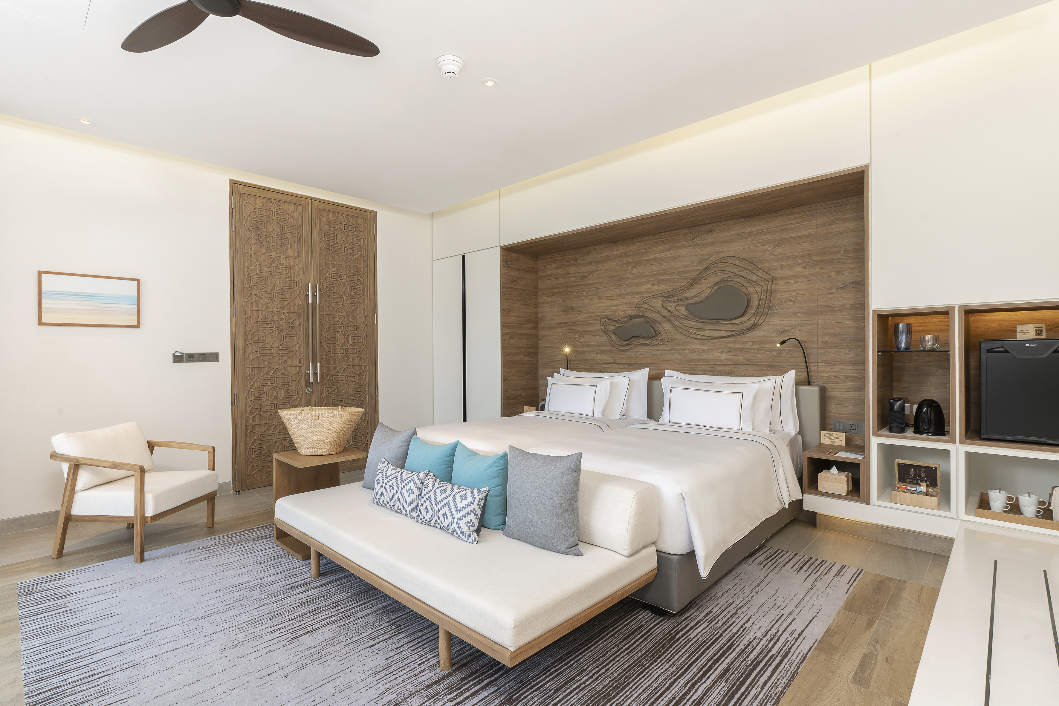 Modern resort bedroom with two beds, wooden features, and stylish decor.