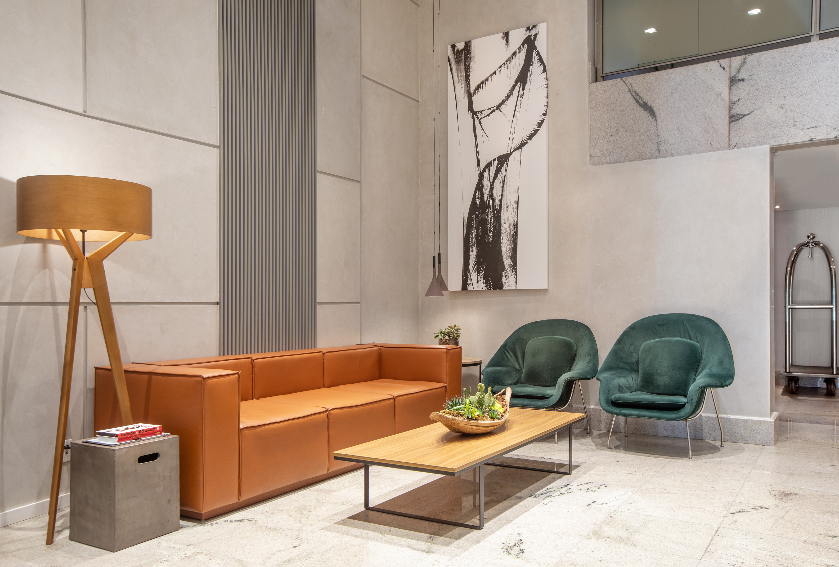 Modern hotel lobby lounge with tan leather sofa, green velvet chairs, coffee table. - -Hotel Madrid Airport Suites Affiliated by Meliá:, Brasilia
