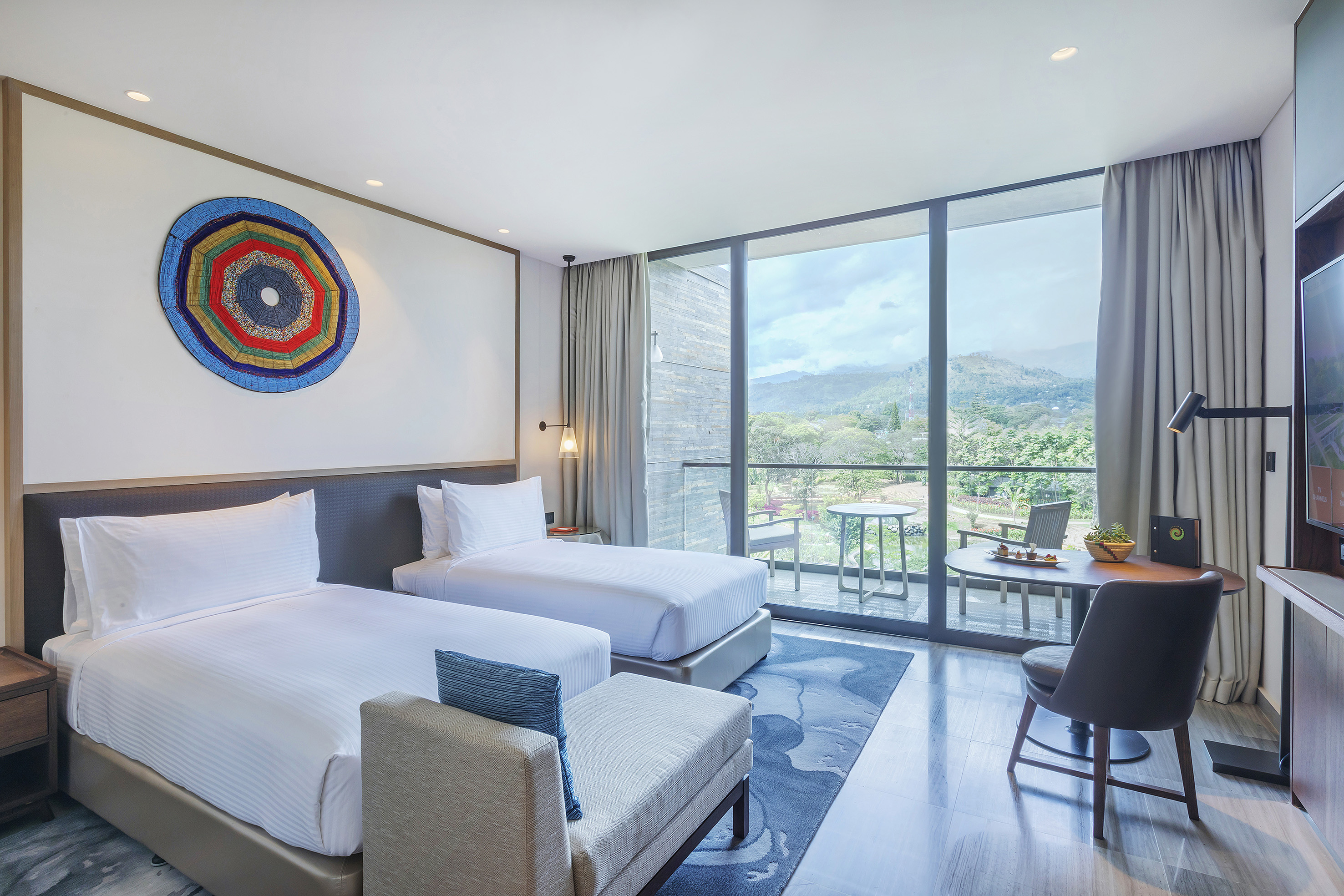 a room with two beds and a table and chairs