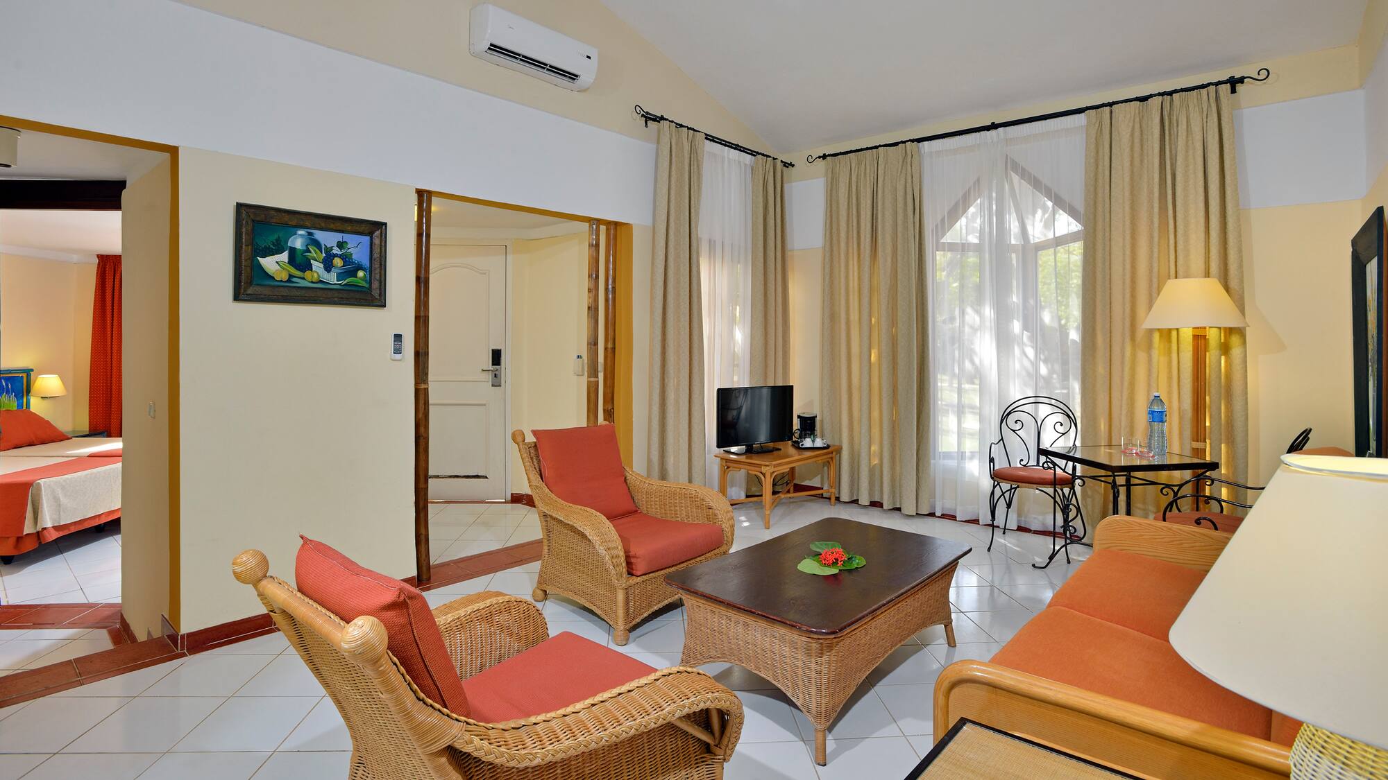 a living room with wicker furniture and a table