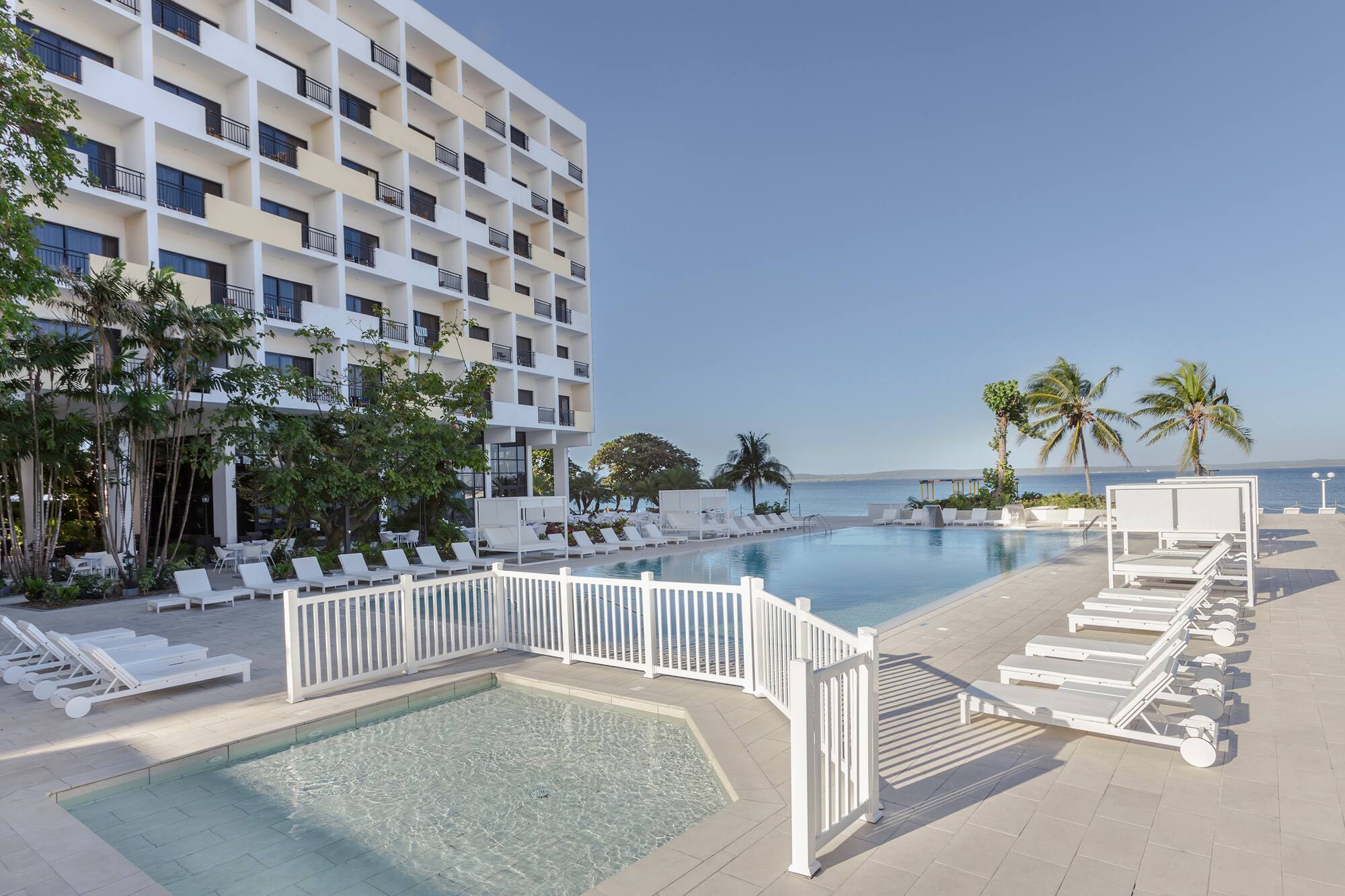a pool with lounge chairs and a building in the background