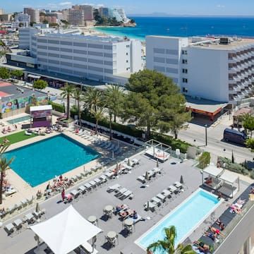 a swimming pool and buildings by the ocean