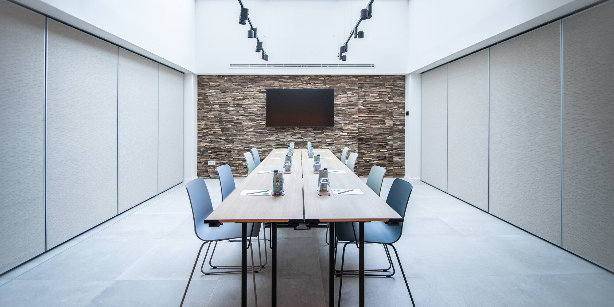 a long table with chairs and a television in the background