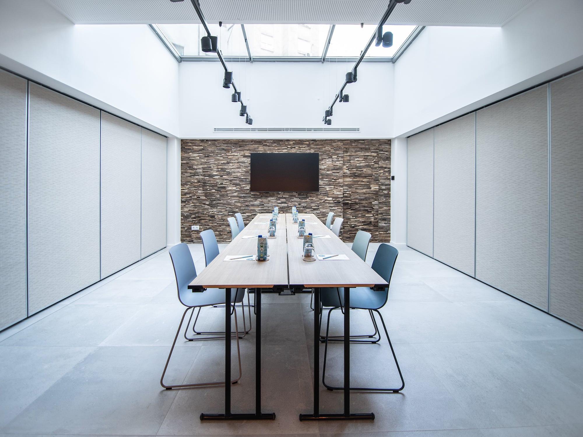 a long table with chairs and a television in the background