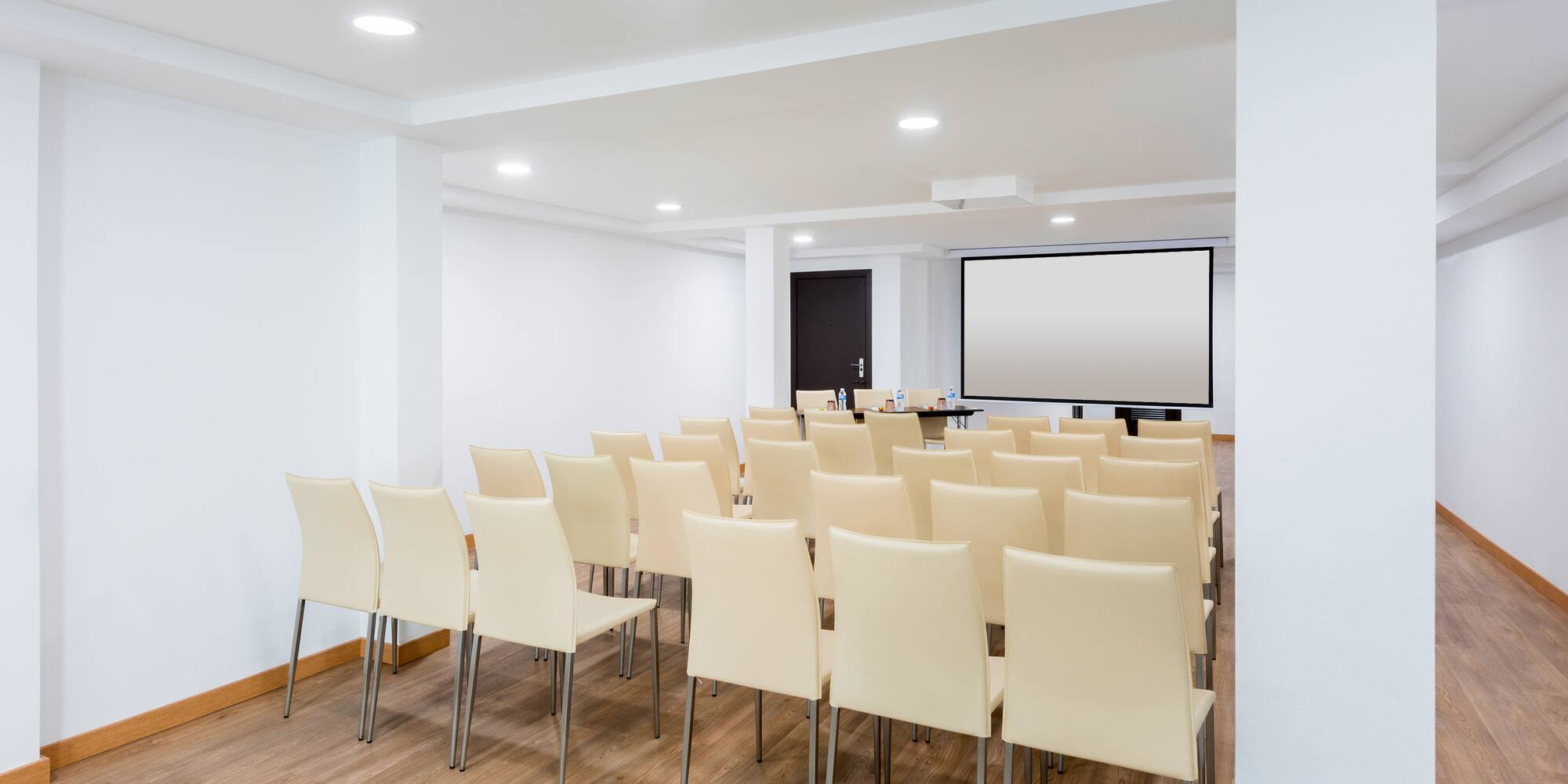a room with chairs and a projector screen