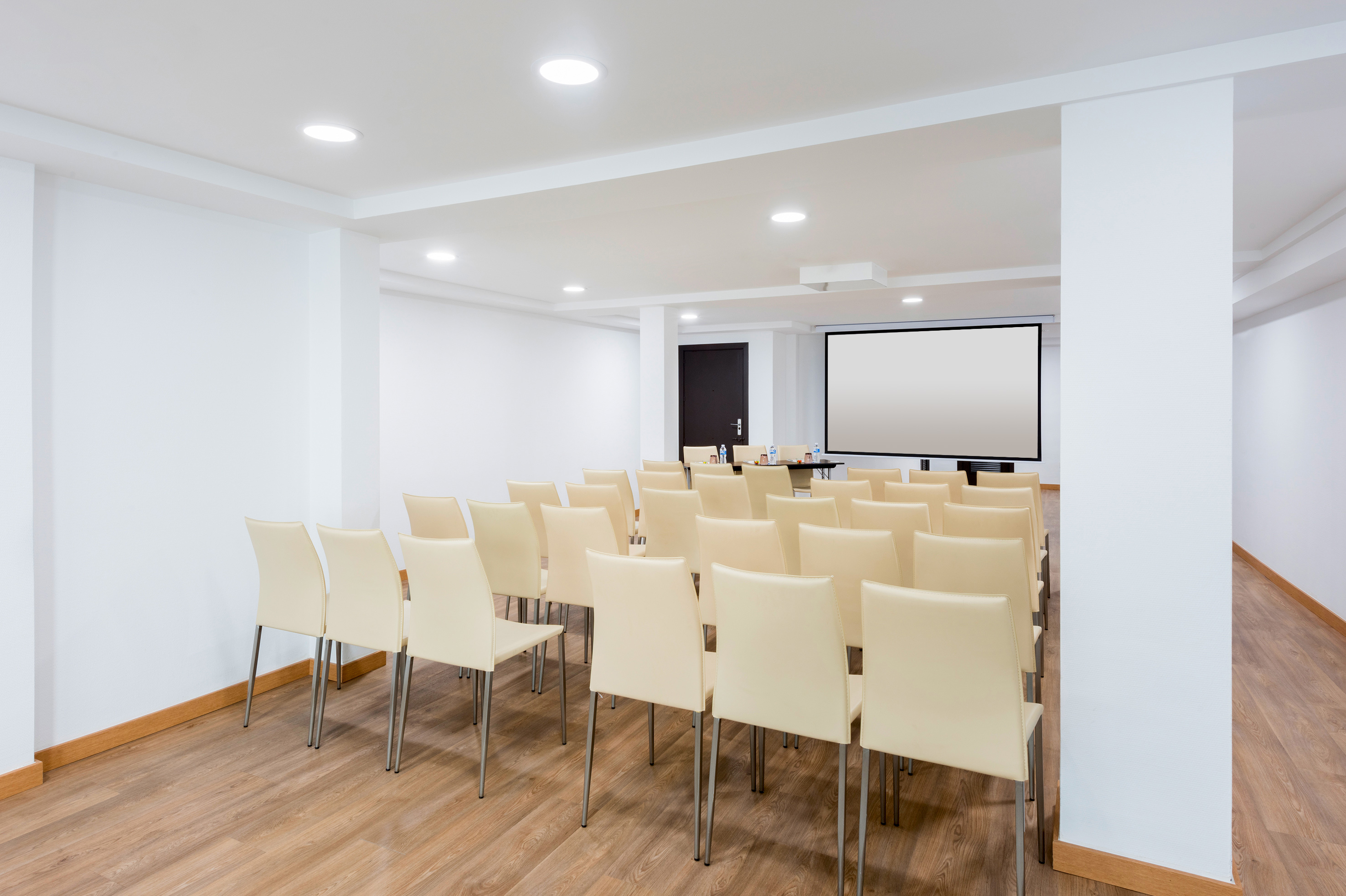 a room with chairs and a projector screen