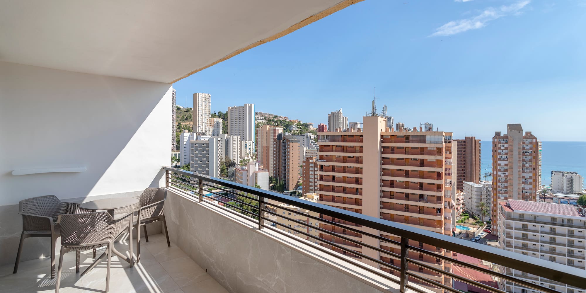 a balcony with chairs and a city view