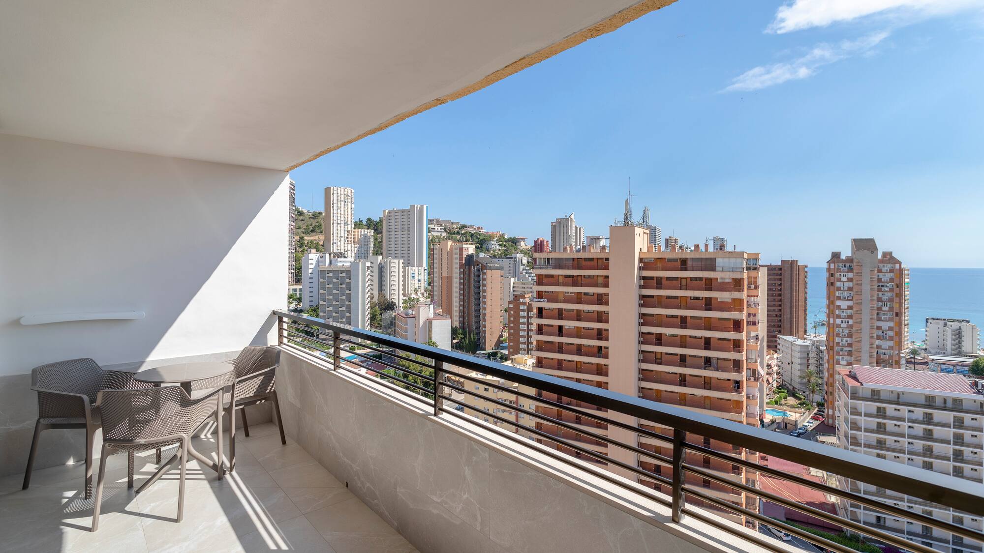 a balcony with chairs and a city view